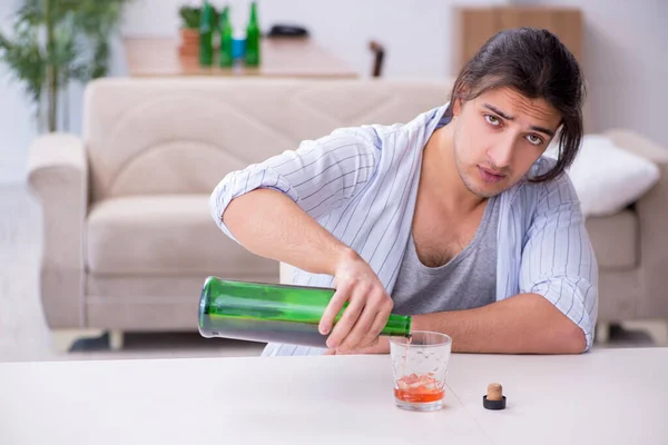 Genç erkek alkolik evde viski içiyor. — Stok fotoğraf