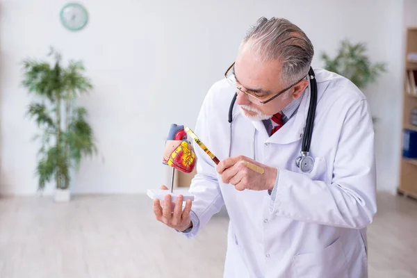 Médico cardiologista idoso trabalhando na clínica — Fotografia de Stock