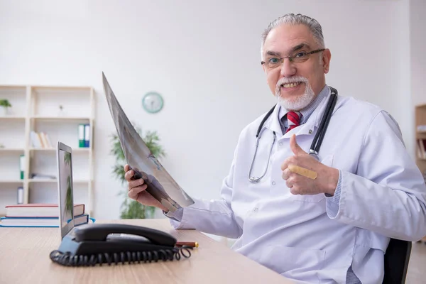 Klinikte çalışan yaşlı bir erkek radyolog. — Stok fotoğraf