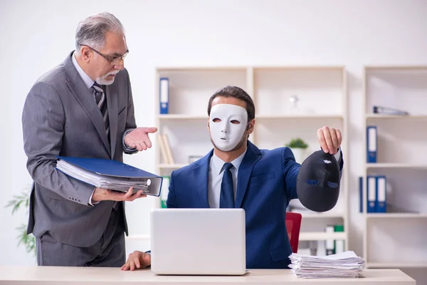 Gammal chef och ung manlig anställd bär masker — Stockfoto
