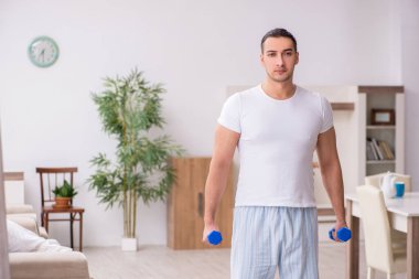 Genç erkek güne sabah egzersizleriyle başlıyor.