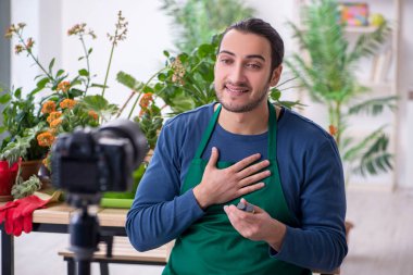 Evin içinde bitkileri olan genç bir erkek bahçıvan.