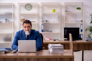 Genç bir erkek işçi aşırı işten memnun değil.