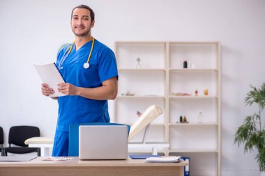 Klinikte çalışan genç erkek doktor.