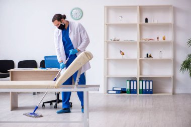 Genç erkek müteahhit salgın konseptinde dezenfekte kliniği