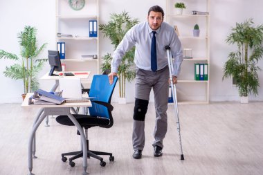 Ofiste çalışan genç bacağı yaralı bir çalışan.