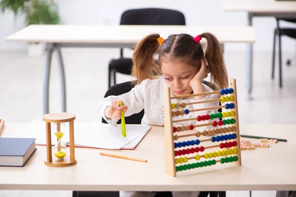 Menina pequena com ábaco na sala de aula — Fotografia de Stock