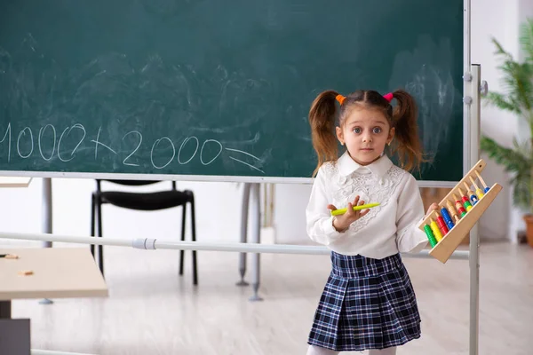 Petite fille devant le tableau noir dans la salle de classe — Photo