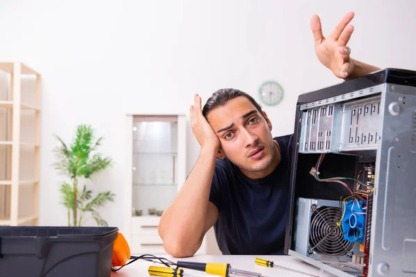 Νεαρός επισκευάζει υπολογιστές στο σπίτι — Φωτογραφία Αρχείου