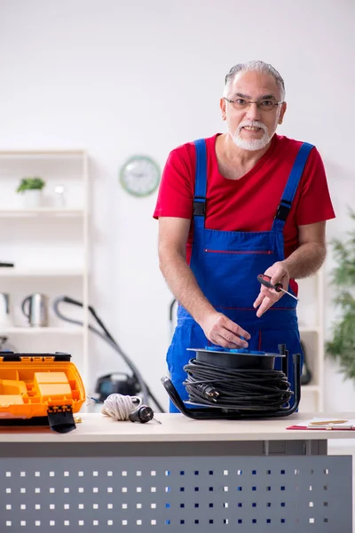 Oude mannelijke aannemer houdt kabel haspel binnen — Stockfoto