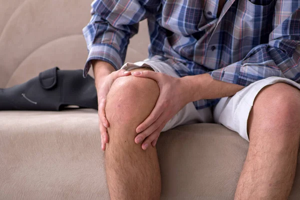 Genç bacağı yaralı adam evde acı çekiyor.