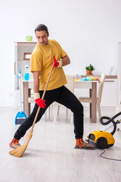 Jovem empreiteiro limpando a casa — Fotografia de Stock