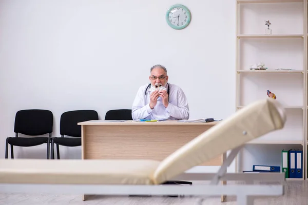 Stary lekarz pracujący w klinice — Zdjęcie stockowe