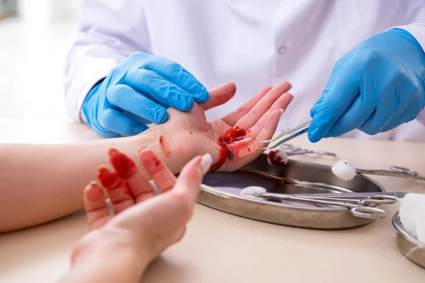 Femme blessée à la main visitant médecin masculin — Photo