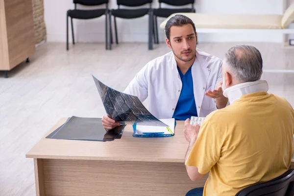 Yaşlı boyun yaralanması genç erkek doktor radyolojisti ziyaret ediyor.