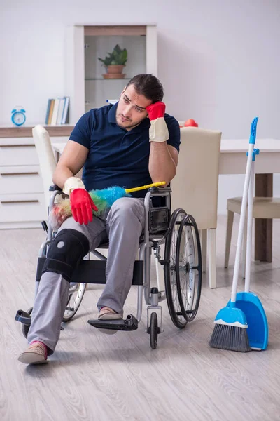 Jonge been gewonde aannemer in rolstoel schoonmaken van het huis — Stockfoto