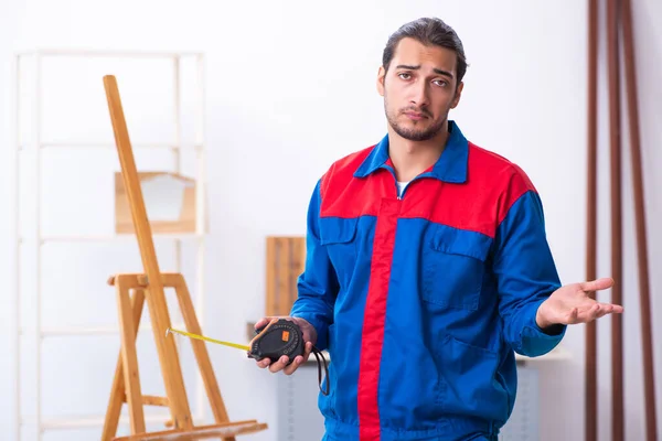 Young male contractor working in workshop