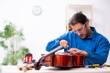 Genç erkek çello tamircisi.