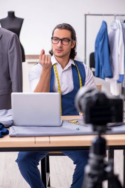 Genç erkek terzi blogu için video kaydediyor.