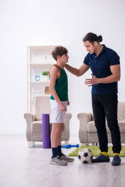 Baba ve oğul içeride spor yapıyor.