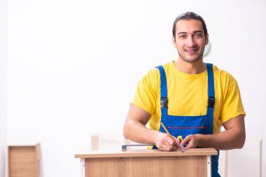 Genç erkek marangoz içeride çalışıyor.