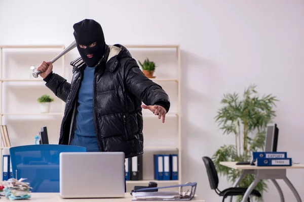 Junger männlicher Einbrecher im Büro — Stockfoto