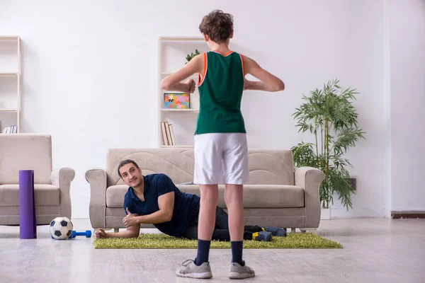 Pai e filho fazendo exercícios esportivos dentro de casa — Fotografia de Stock