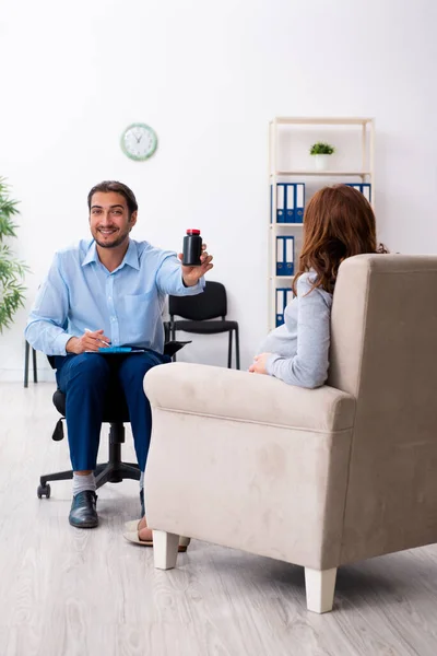 Zwangere vrouw op bezoek bij jonge mannelijke psycholoog — Stockfoto