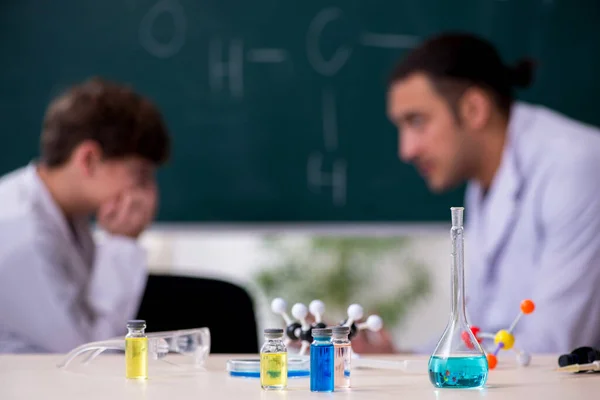 Jovem professor de química e estudante em sala de aula — Fotografia de Stock