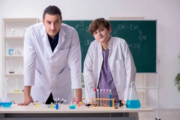 Joven profesor de química y colegial en el aula —  Fotos de Stock