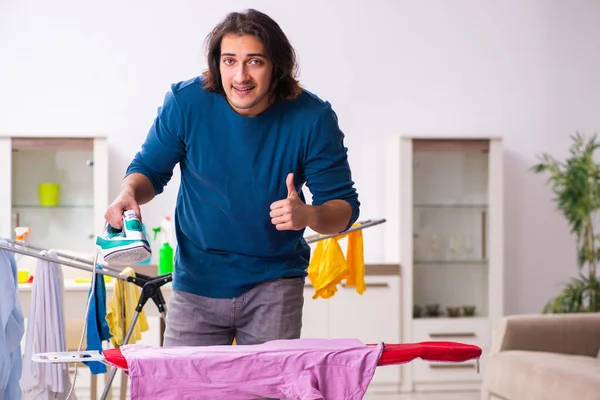 Joven marido haciendo planchado de ropa en casa — Foto de Stock