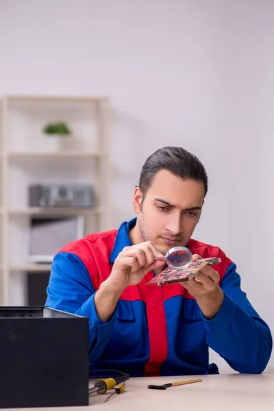 Jovem reparador do sexo masculino reparando computador — Fotografia de Stock