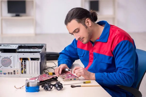 Jovem reparador do sexo masculino reparando computador — Fotografia de Stock
