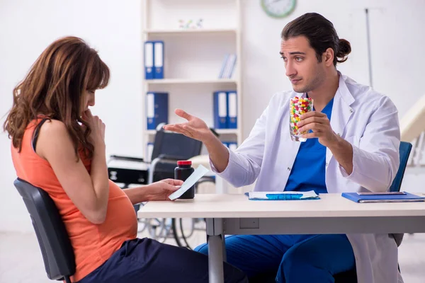 Těhotná žena na návštěvě mužského lékaře gynekolog — Stock fotografie