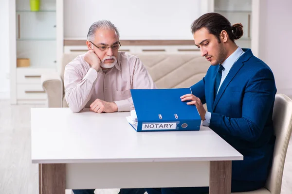 Jonge mannelijke advocaat op bezoek oude man in testament concept — Stockfoto