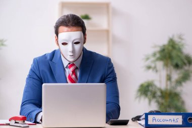 İkiyüzlülük konseptinde maske takan erkek çalışan.