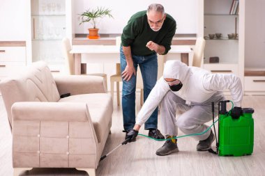 Genç erkek dezenfektan ve yaşlı adam içeride.