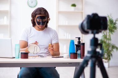 Genç erkek kozmetikçi blogu için video kaydediyor.
