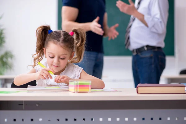 Junge Eltern, alter männlicher Lehrer und kleines Mädchen im Klassenzimmer — Stockfoto