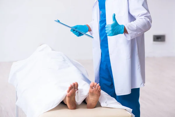 Police coroner examining dead body corpse in morgue — Stock Photo, Image