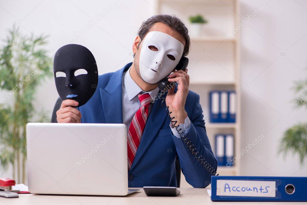 Male employee with mask in hipocrisy concept