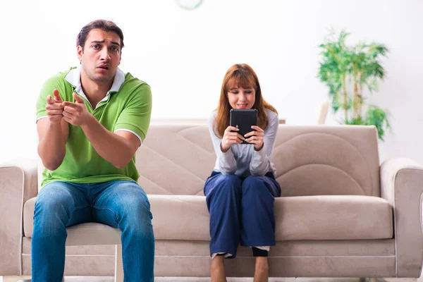 Pareja joven en concepto de dependencia gadget — Foto de Stock