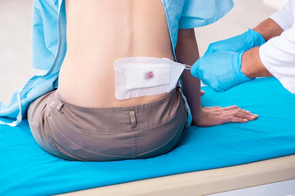 Mujer joven lesionada visitando al joven médico masculino — Foto de Stock