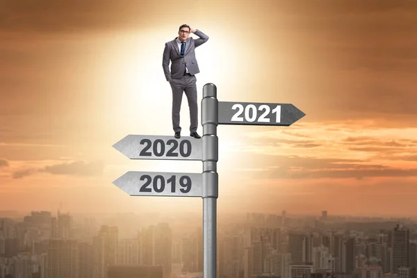 Road sign and businessman with 2020 and 2021 — Stock Photo, Image