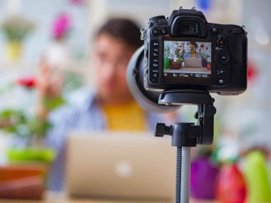 Erkek çiçekçi vlogger blogcusu kameraya video çekiyor