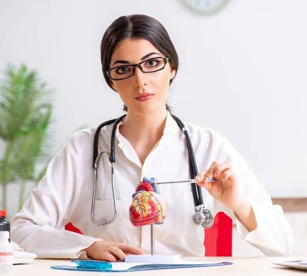 Woman doctor showing heart model to students — Stock Photo, Image