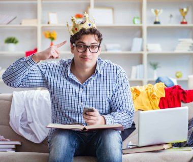 Genç adam dağınık bir odada çalışıyor.