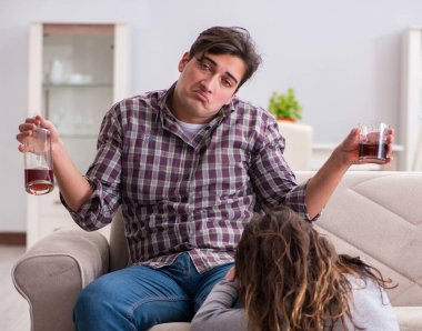 Genç bir aile kavramında içki sorunu yaşayan sarhoş bir koca.