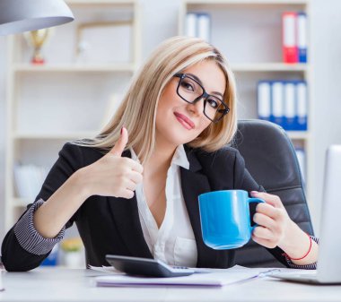 Ofisteki masada dizüstü bilgisayarda çalışan iş kadını.