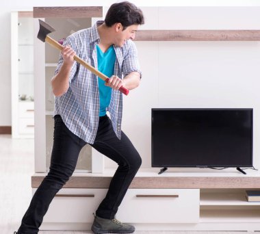 Bozuk televizyonu tamir etmeye çalışan adam